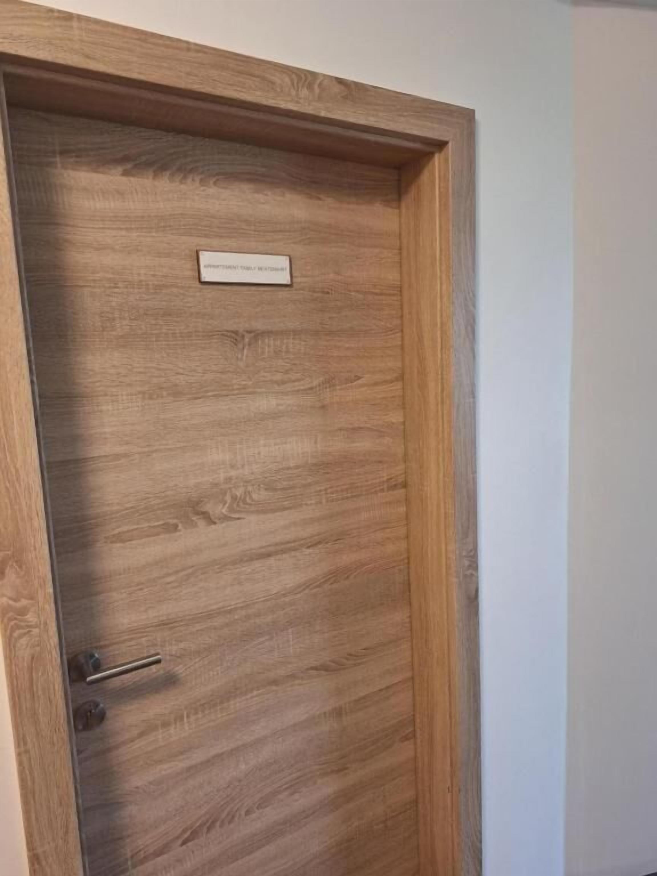 A wooden door with a nameplate and a handle.
