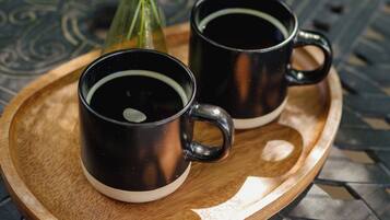 Two black mugs on a wooden tray.