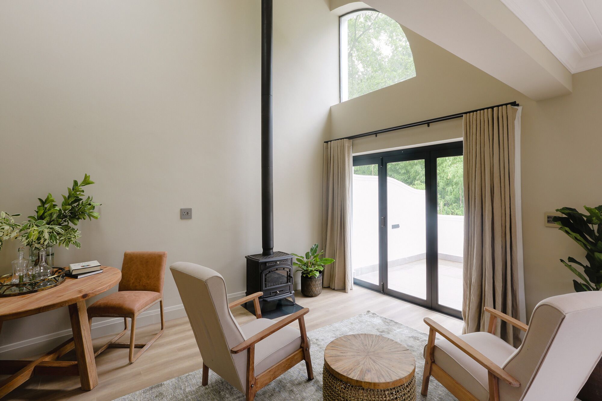 A modern living room with a fireplace, a dining area, and a large sliding glass door to the outdoors.