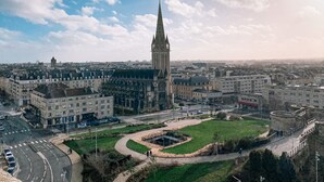A cityscape with a prominent tower, a roundabout, and surrounding buildings.
