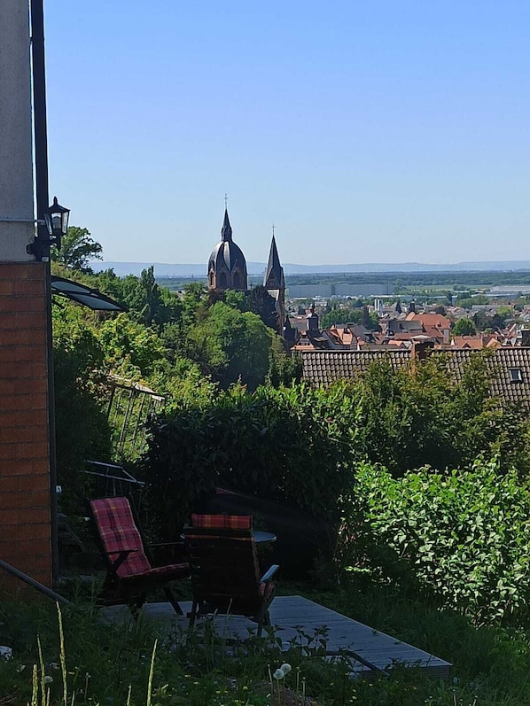 En vy över en kyrka med en kupol och torn, omgiven av grönska och bostadshus.