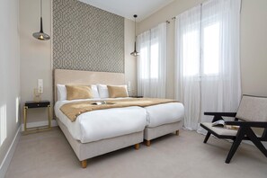A modern bedroom with a large bed, bedside tables, a reading chair, and patterned wallpaper. - Exclusive Penthouse With Private Terrace in Granada San Anton 402 (Granada)