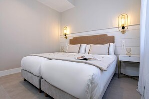A neatly made bed with a headboard, two bedside tables with lamps, and a magazine on the bed. - Luxury Penthouse With Private Terrace in Granada San Anton 401 (Granada)