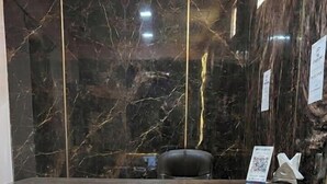 Un mostrador de recepción con una pared de mármol y un cartel que dice 'RECEPTION'.