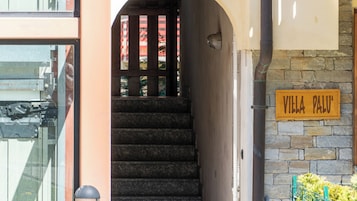 Una escalera conduce a una puerta con un cartel que dice 'VILLA PALU'.