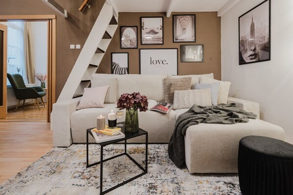 Un salon moderne avec un canapé, une table basse et un escalier.
