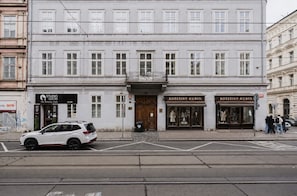 Ein Gebäude mit einer Schaufensterschild 'KOZESINY-KUBIN' und einem weißen Auto davor.