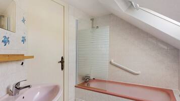 Une salle de bain équipée d’un lavabo, d’une baignoire et d’une douche.
