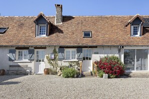 A two-story building with a stone roof, a front door, and a gravel driveway. - Guest Room 'La Ferme Des Bigornes - Lion' with Shared Terrace, Garden & Wi-Fi (Châtillon-sur-Indre)