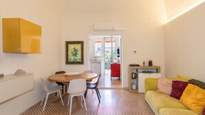 A compact living space with a dining area, a sofa, a kitchen area, and a door leading to an outdoor area. - Apartment 'Terraviva - La Terrazza Sul Nespolo' with Private Terrace, Wi-Fi and Air Conditioning (Cecina)