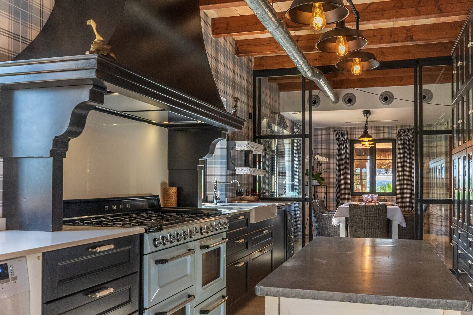Een moderne keuken met een groot fornuis, oven en een eethoek met een tafel.