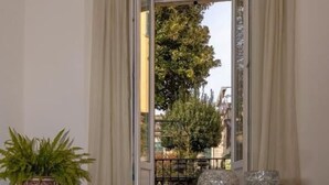 A room with a glass table reflecting the outside view, a potted plant, and two crystal glassware items. - Appartamento The Rich Man (Bellagio)