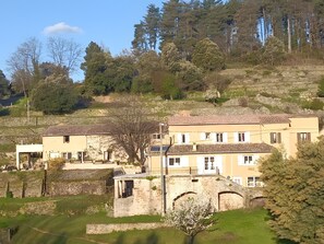 A hillside property with stone buildings, a large tree, and a clear sky. - Cottage 'Du Mas St Esprit' with Shared Pool, Wi-Fi and Air Conditioning (Largentière)