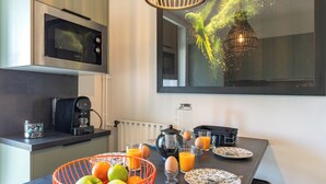 A modern kitchen with a microwave, coffee maker, and fruit bowl. - Companies, large families, free parking (ROUEN)