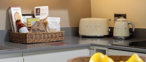 Una cucina con un cesto di viveri, un tostapane e una macchina da caffè.