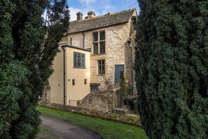 A stone building with a traditional design, featuring a central window and a door. - Church Alley House (Cheltenham)