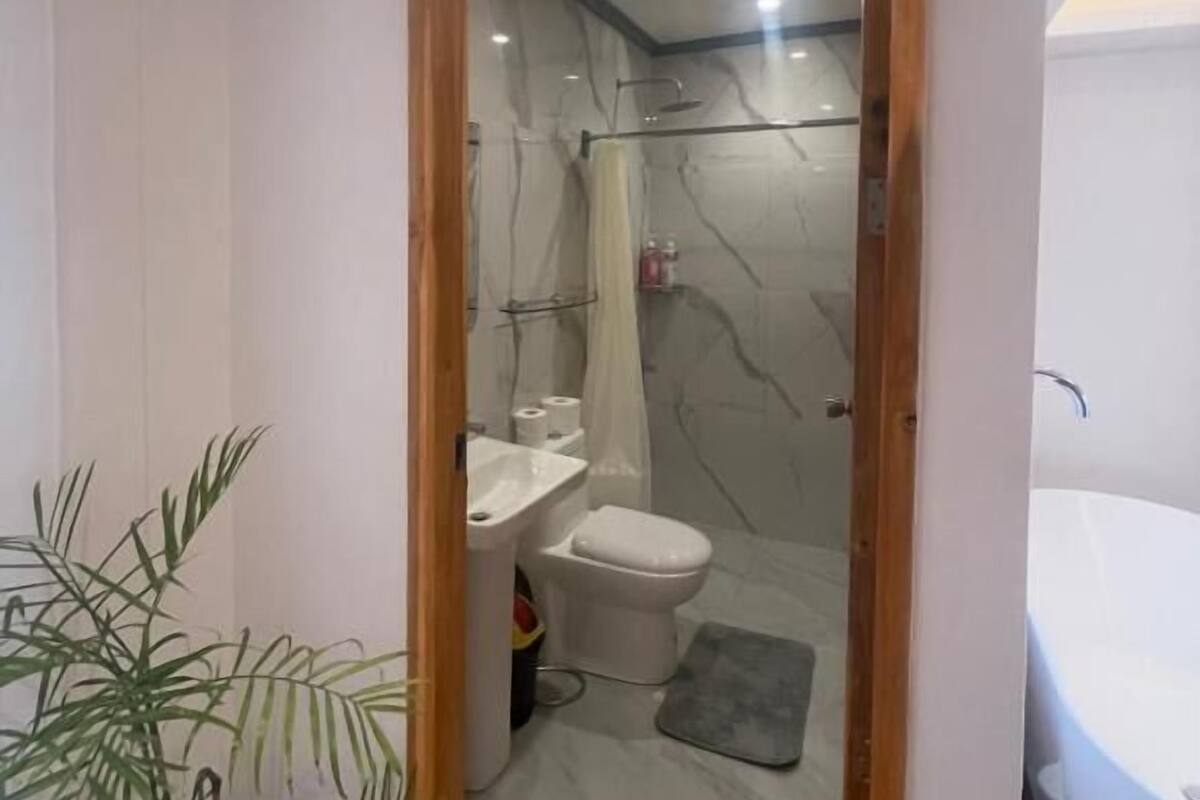 A bathroom with a shower, toilet, sink, and a bathtub.