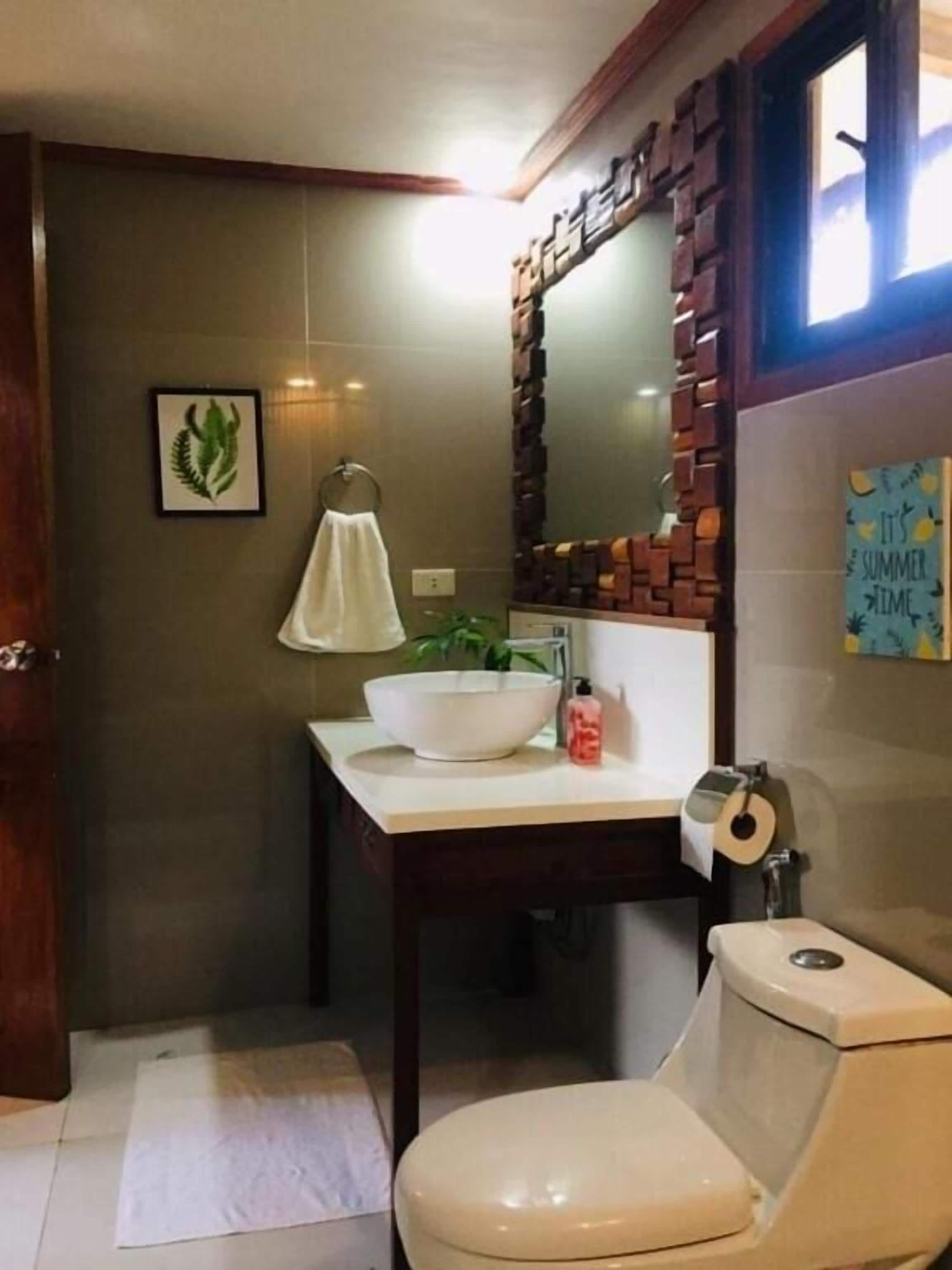 Ein Badezimmer mit Toilette, Waschbecken und Spiegel.