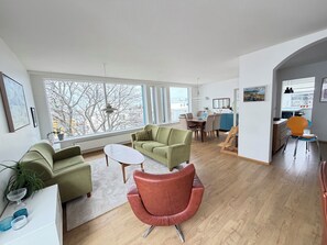 A modern living room with a sofa, armchair, and dining table. - Modern apartment centrally located in Reykjavik (Reykjavík)