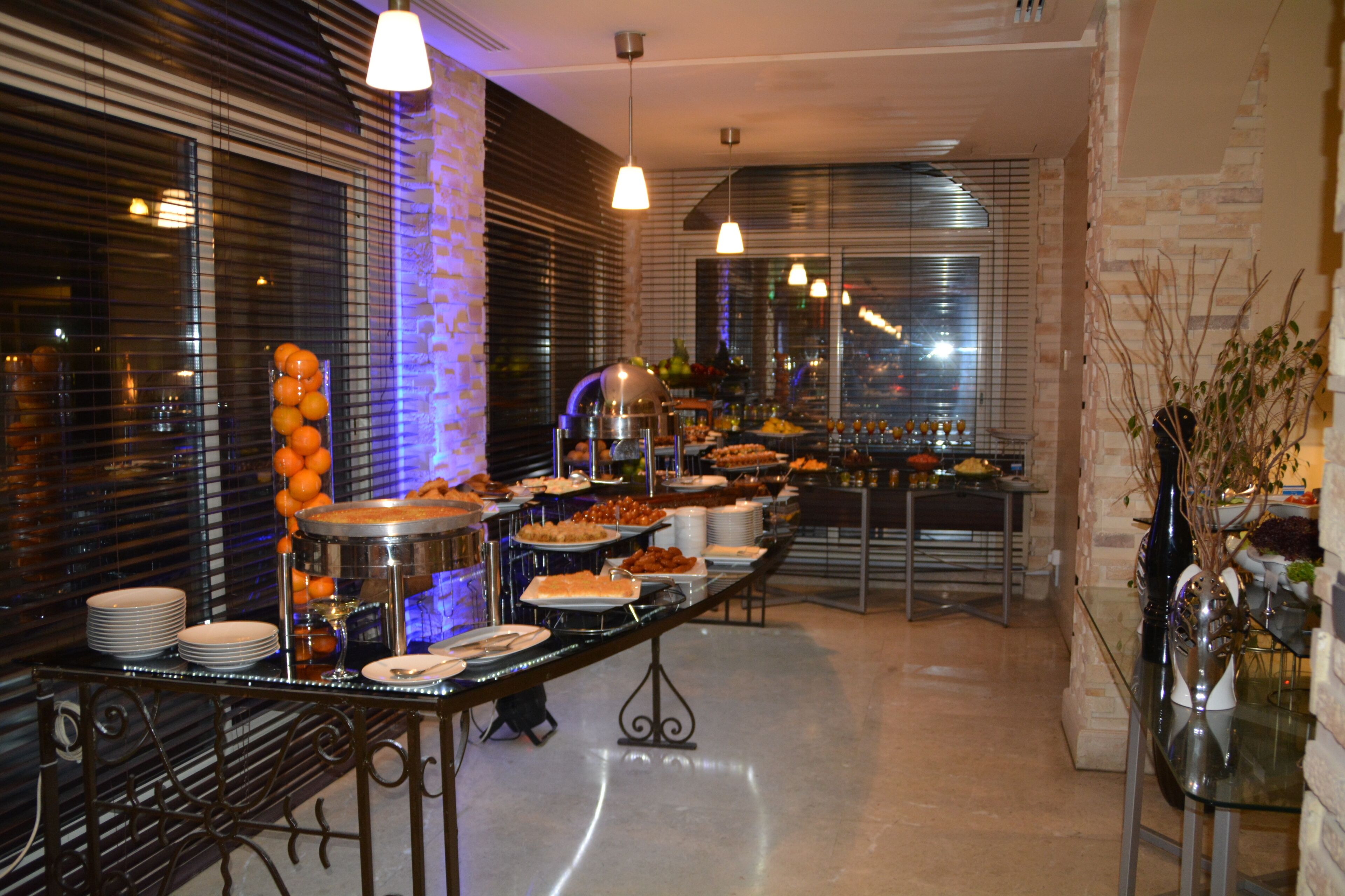 A buffet setup with various food items and a long table.