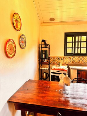 A kitchen with a coffee maker, a stove, and a window with a view.
