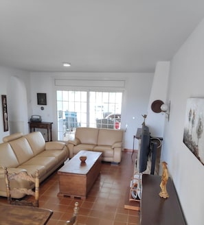 A living room with a sofa, a coffee table, a TV, and a statue. - Fantástica casa a primera linea del mar en empuriabrava (Empuriabrava)