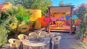 A patio with a stone fire pit, plastic chairs, and a table. - dome suite domes (Loreto)