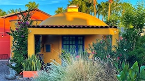 A yellow house with a red roof, surrounded by greenery and flowers. - dome suite domes (Loreto)