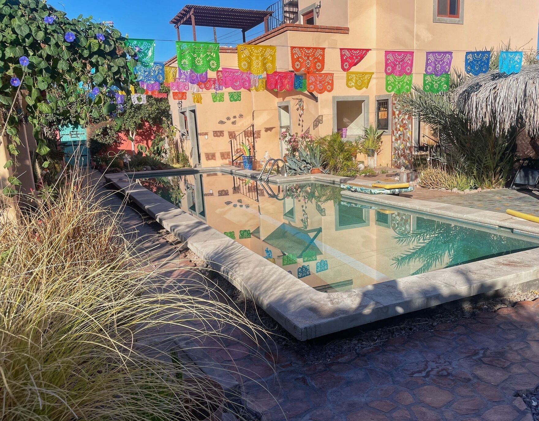 Una piscina al aire libre, sombrillas, tumbonas