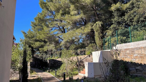 A pathway leading to a building with stone walls and a metal fence. - Villa Rosa By Avecoeur (Sainte-Maxime)
