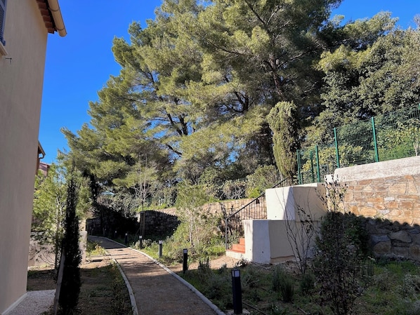 A pathway leading to a building with stone walls and a metal fence. - Villa Rosa By Avecoeur (Sainte-Maxime)