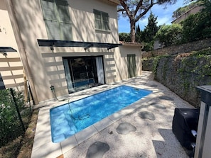 A rectangular swimming pool with a clear blue water surface, surrounded by a concrete deck with circular indentations. - Villa Rosa By Avecoeur (Sainte-Maxime)