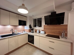 A compact kitchen with a sink, microwave, toaster, and a window above the counter. - Villa Rosa By Avecoeur (Sainte-Maxime)