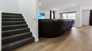 Ein modernes Interieur mit Treppe, einer Sitzecke und Blick durch eine Glastür.