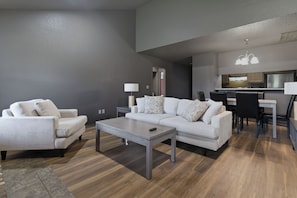 Un salon moderne comprenant un canapé, un fauteuil, une table basse et un coin repas.