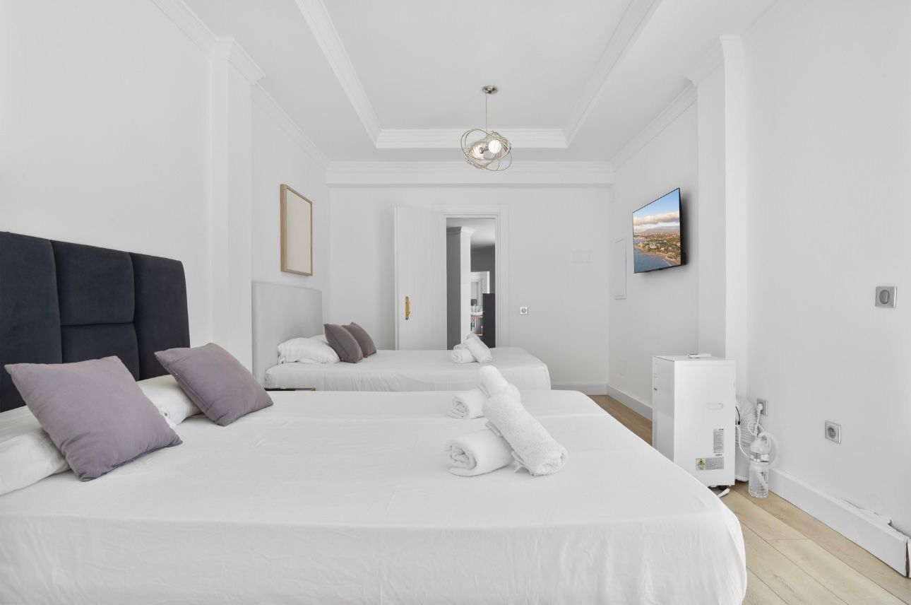 Et moderne hotelværelse med en stor seng, et fladskærms-tv og udsigt over byen.