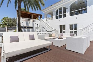 A white outdoor lounge area with a sofa, armchairs, and a coffee table. - Villa Elviria (Marbella)