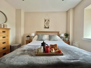 A neatly made bed with a tray of breakfast items, a bedside table with a lamp, and a wall-mounted decorative piece. - Tumbledown Croft.
Beautiful cottage in Aberdeenshire countryside near Cruden Bay (Hatton)