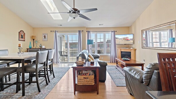 A living room with a dining table, chairs, a sofa, a fireplace, and a television.
