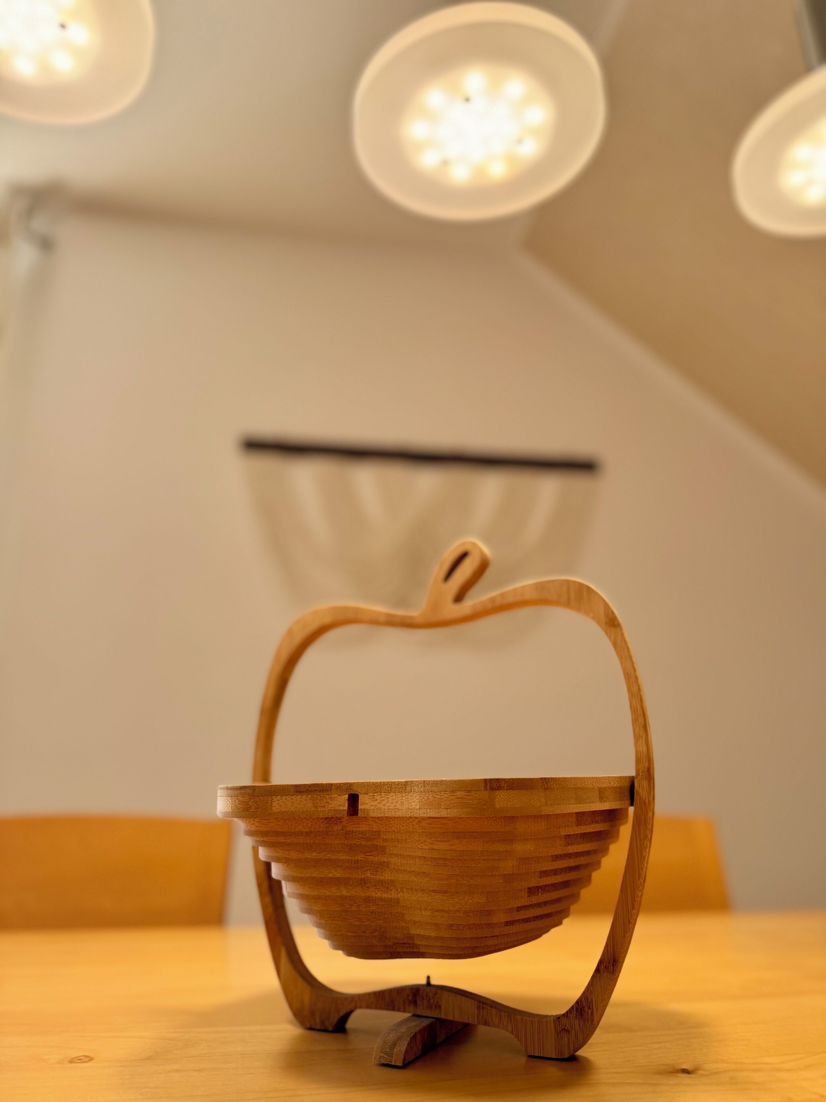 A wooden basket with a handle on a table.