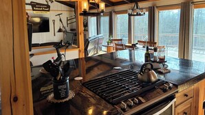 Cucina con un'isola grande, travi in legno, zona pranzo con vista e un segnale che indica la presenza nella Foresta Nazionale delle Montagne Bianche.