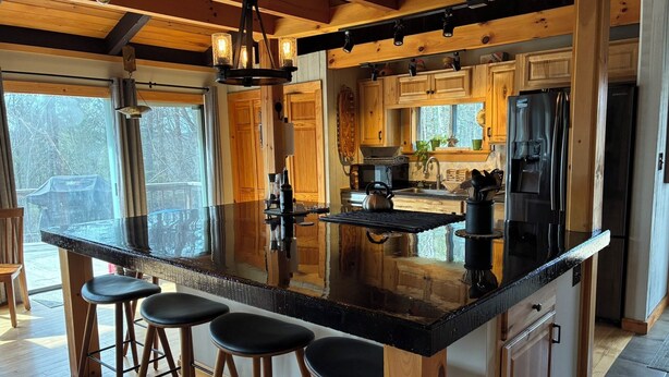 Una cucina con una grande isola, mobili in legno e sgabelli da bar.