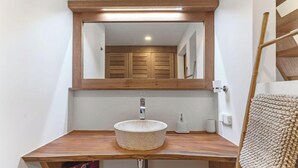 A bathroom with a wooden vanity, a round basin, a mirror, and a towel rack. - Coastal Bliss 1BR Bungalow by the Sea in Moorea (Moorea-Maiao)