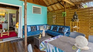 A cozy room with a blue sofa, a dining table, and a statue.