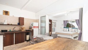 A compact hotel room with a kitchenette, a dining area, and a bed with a view. - Seaside Serenity 2BR Oasis on Enchanting Moorea (Moorea-Maiao)