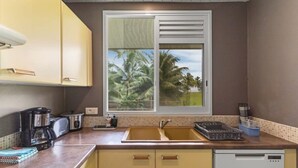 A kitchen with a window, a sink, a coffee maker, and a dishwasher. - Seaside Paradise Retreat - 3BR House in Moorea (Moorea-Maiao)