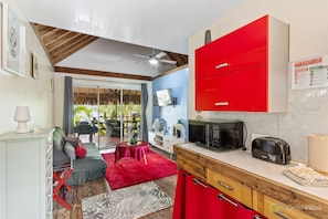 A compact kitchen with a red cabinet, a microwave, and a toaster.