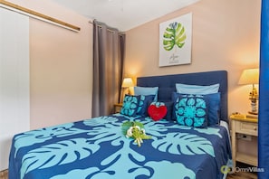 A bedroom with a bed, a nightstand, a lamp, a wall art piece, and a curtain.
