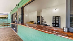 A modern kitchen with a wooden countertop, a sink, and a cabinet. - Temenino Pihiti Secluded Bungalow (Taiarapu-Ouest)