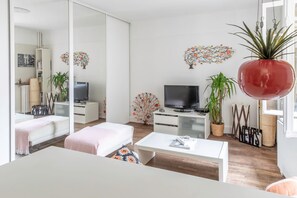 Ein stilvolles Wohnzimmer mit Sofa, Couchtisch, Fernseher und Zimmerpflanzen.